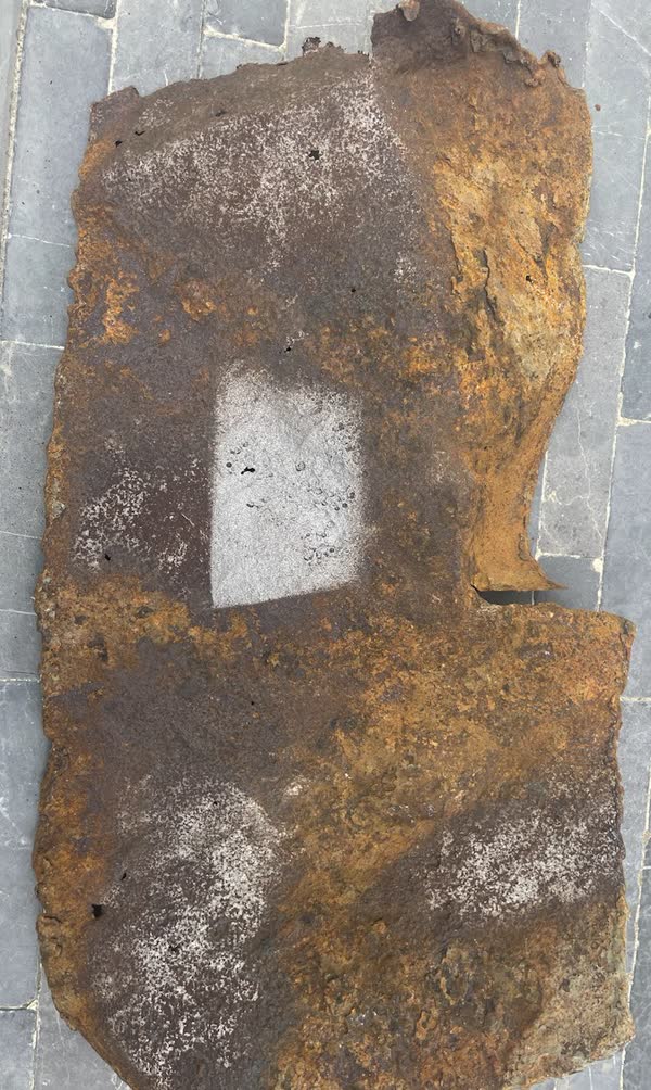Heavily rusted plate with a blasted square